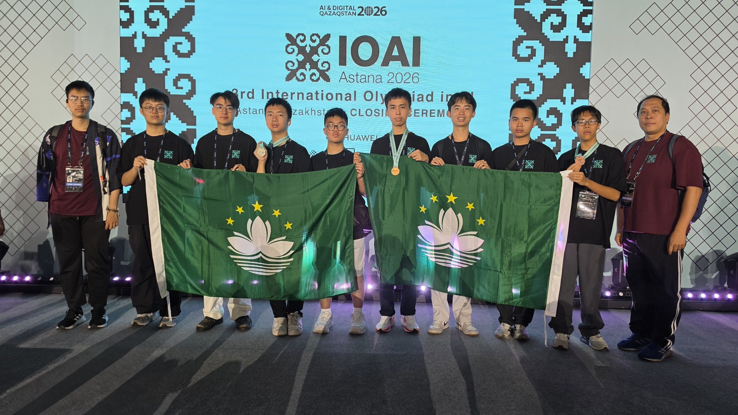 澳門代表隊於 IOAI 2026 閉幕禮與澳門區旗合照。